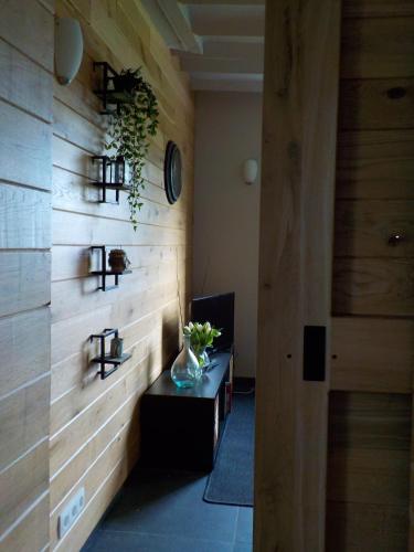 a room with a wooden wall with a vase on a table at La petite Juliette in Leuze-en-Hainaut