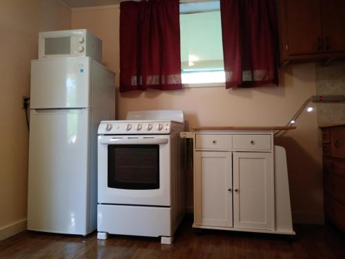 a kitchen with a white stove and a refrigerator at Riverbend Lodging in Bryson City