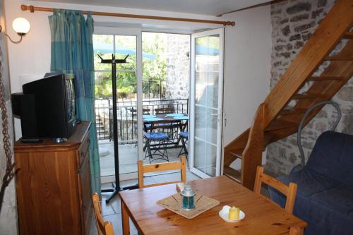 un salon avec un canapé et une table avec une télévision dans l'établissement L'Avventura gîte bleu, à Grospierres