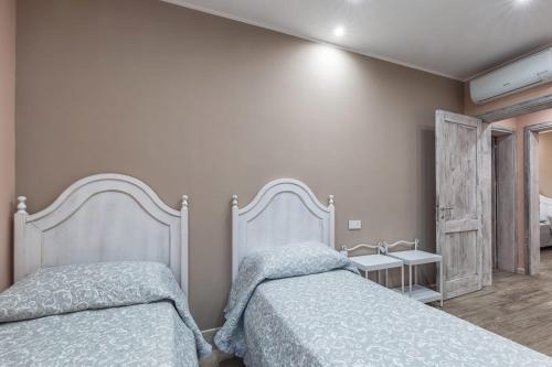 a bedroom with two beds and a side table at B&B da Chiara in Tortolì