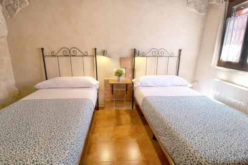 two twin beds in a room with at CASAS LA MURALLA de Bodegas Marcos in Peñafiel