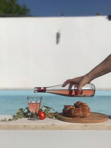 a person is pouring wine into a plate of food at Casas do Patheo in Óbidos