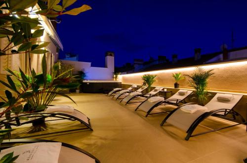 a row of chairs on a balcony at night at Villa Brandestini in Pula