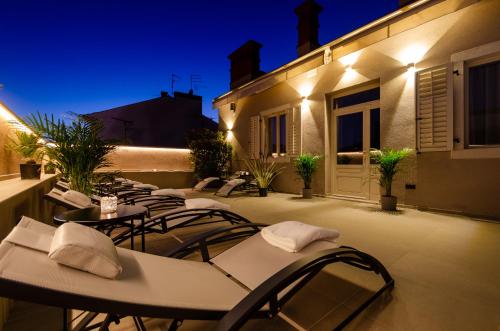 a group of chairs and tables on a patio at night at Villa Brandestini in Pula