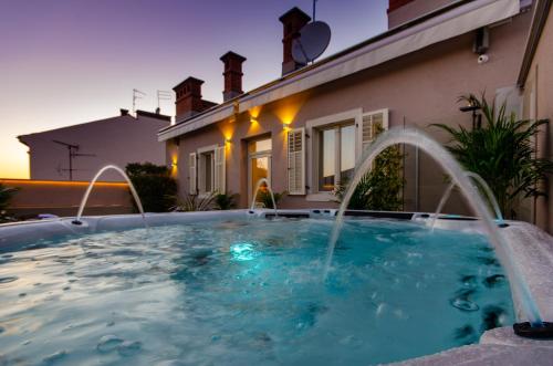 a swimming pool with fountains in front of a house at Villa Brandestini in Pula