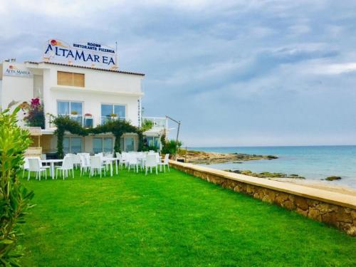 a building with white chairs and the ocean at Relax Near The Sea in Noto Marina