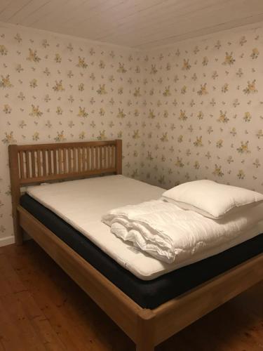 a bed in a bedroom with flowers on the wall at Yxefall Norrgården in Kisa