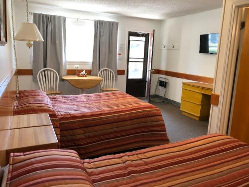 une chambre d'hôtel avec deux lits et un canapé dans l'établissement Yellow Quill Motel, à Portage La Prairie