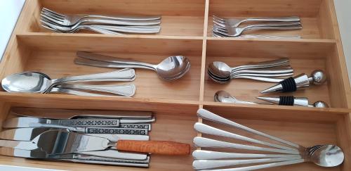 a wooden drawer filled with silver utensils at The OldMillhouse in Mojstrana