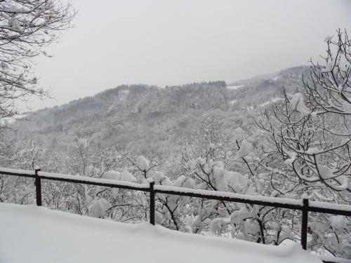 a fence covered in snow in front of a mountain at la casa sull'arcobaleno 1 in Manta