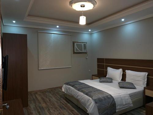 a bedroom with a bed and a projection screen at Dorar Rabigh Complex Residential Units in Rabigh