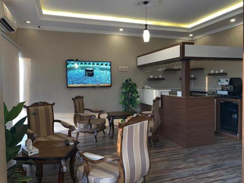 a restaurant with chairs and a bar with a tv on the wall at Dorar Rabigh Complex Residential Units in Rabigh