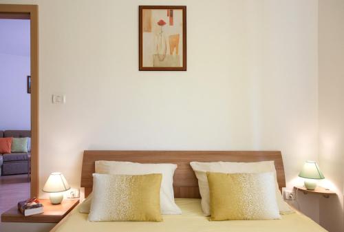 una camera bianca con un letto con due lampade di Apartment Helga a Ližnjan (Lisignano)