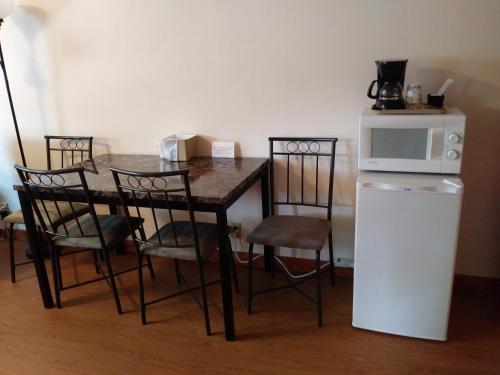 a table and chairs with a microwave and a refrigerator at Riverbend Lodging in Bryson City