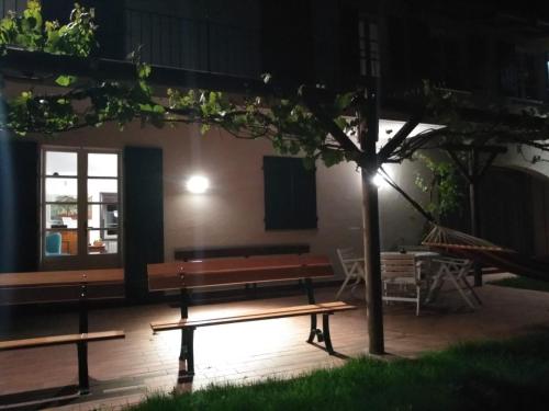 a couple of benches in front of a building at night at AMERICA NEI BOSCHI B&B in Bra