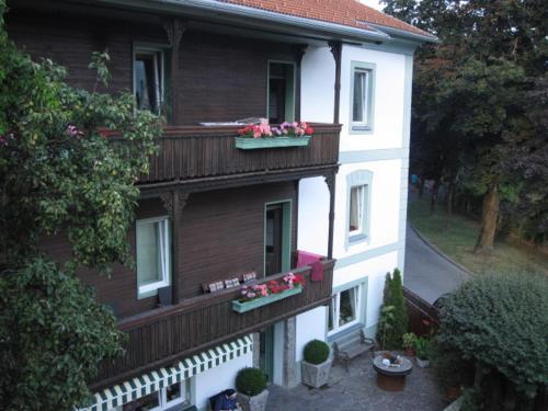 a building with two balconies with flowers on it at Ferienwohnung Lienz Egger in Lienz