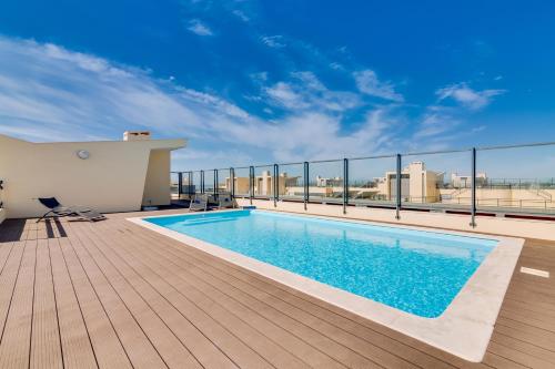 a swimming pool on the roof of a building at Ria House - beautiful apartment with swiming pool in Olhão