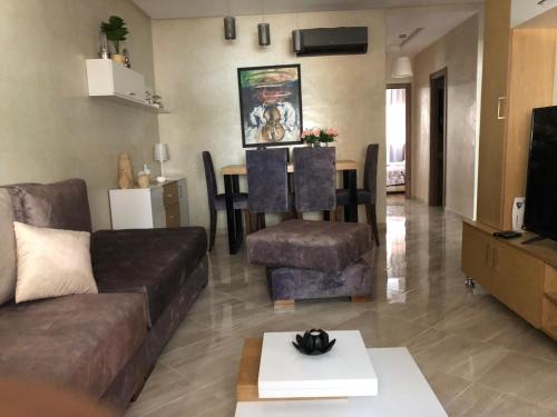 - un salon avec un canapé et une table dans l'établissement Appartement haut standing, à Marrakech