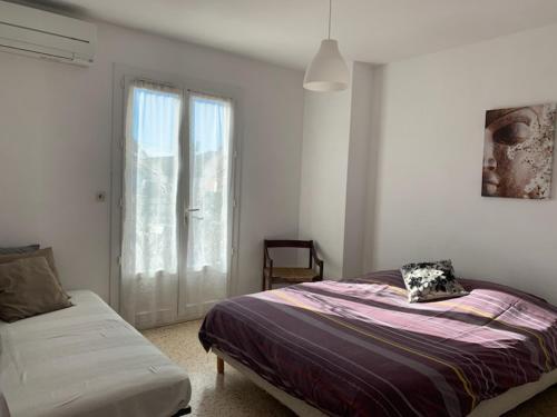 une chambre avec un lit, une fenêtre et un canapé dans l'établissement Maison Bord de Mer, à Six-Fours-les-Plages