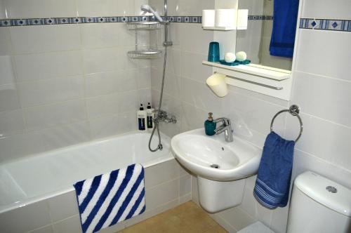 a bathroom with a sink and a toilet and a tub at Millie's Apartments in Ayia Napa