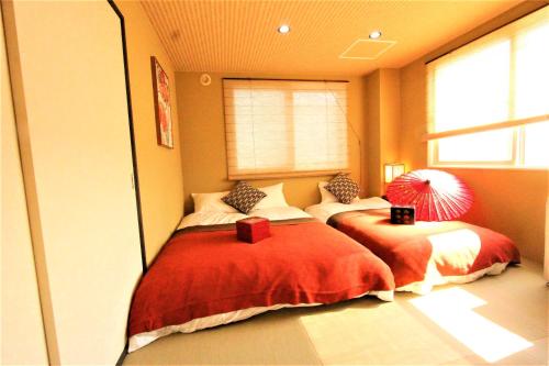 a bedroom with two beds and a window at Wayado Sapporo Ciao in Sapporo