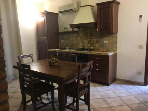 a kitchen with a wooden table with chairs and a stove at Serenella Apartament in San Vito lo Capo