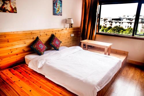 a bedroom with a white bed and a window at Lakeside Inn in Guilin