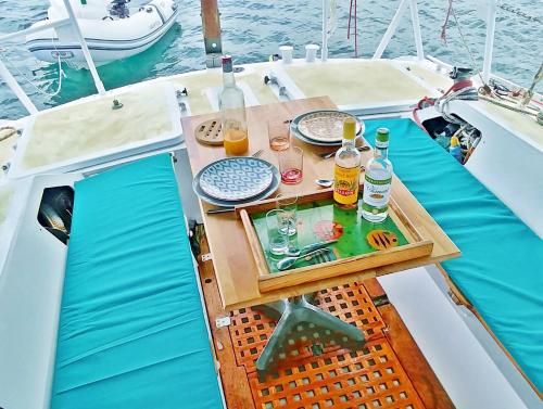 a table on the deck of a boat with drinks at Bateau Kyma in Sainte-Anne