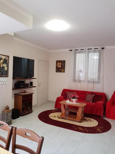 a living room with a red couch and a table at B&B la casetta di Lilly in Amelia
