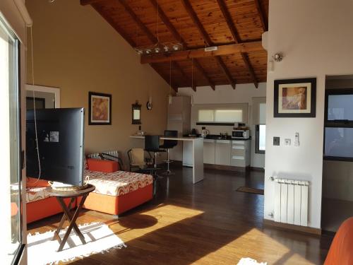 a large living room with a couch and a kitchen at La Macarena Suites in Villa General Belgrano