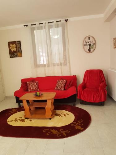 a living room with a red couch and a table at B&B la casetta di Lilly in Amelia