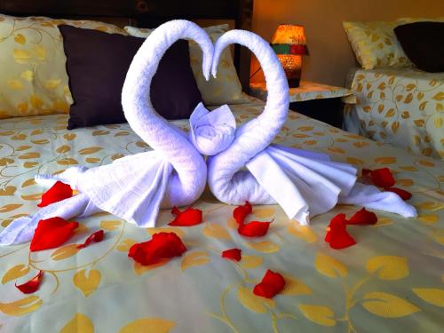 two swans made out of towels on a bed at Aunty Arenal Lodge in Fortuna