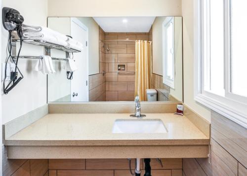 uma casa de banho com um lavatório e um chuveiro em Sea Rock Inn - Long Beach em Long Beach