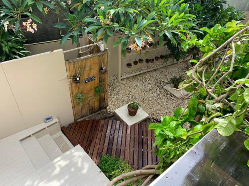 a small garden with a wooden deck with a door at Mama Beach Residence - Adults Only in Phi Phi Islands