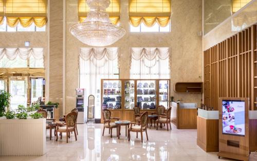 a restaurant with tables and chairs and a chandelier at Royal Chiayi Hotel in Chiayi City