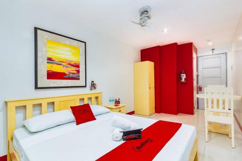 een slaapkamer met een wit bed en een rode deken bij RedDoorz near Cebu Metropolitan Cathedral in Cebu City