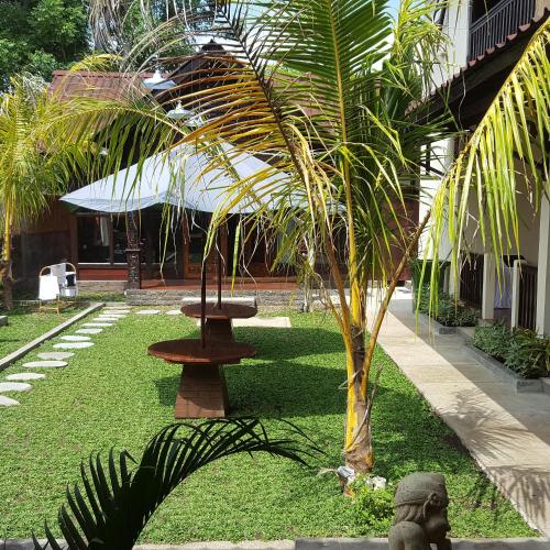 a park with a table and a palm tree at Gili Buana Hostel & Backpackers Gili Air in Gili Air