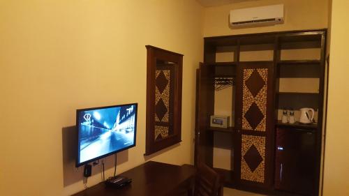 a living room with a flat screen tv on a wall at Gili Buana Hostel & Backpackers Gili Air in Gili Air