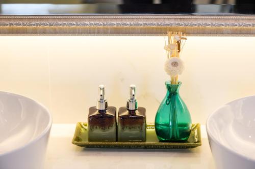 three bottles on a gold tray in front of a mirror at Villa Seville in Hua Hin