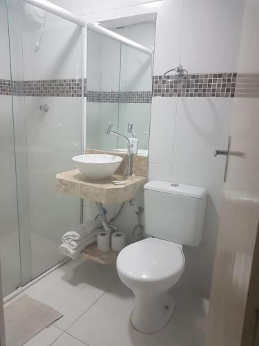 a bathroom with a white toilet and a sink at Hotel Morada do Mar in Guarujá
