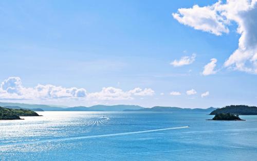 a view of a large body of water with mountains at Shorelines in Hamilton Island