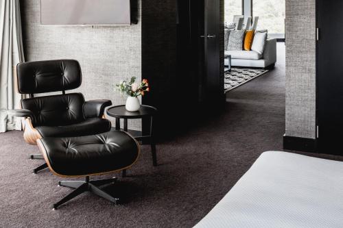 a salon with a chair and a couch in a room at Bolton Hotel in Wellington