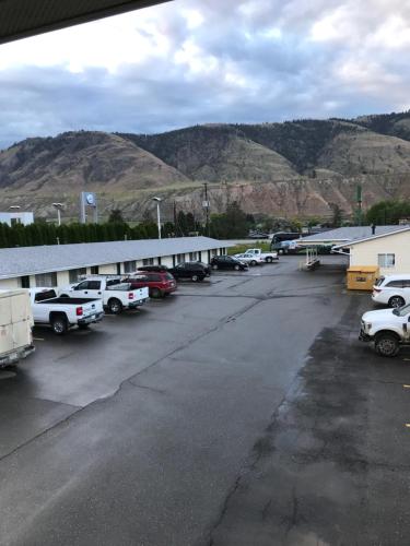 a parking lot with cars parked in front of a building at Trans Canada Motel in Kamloops