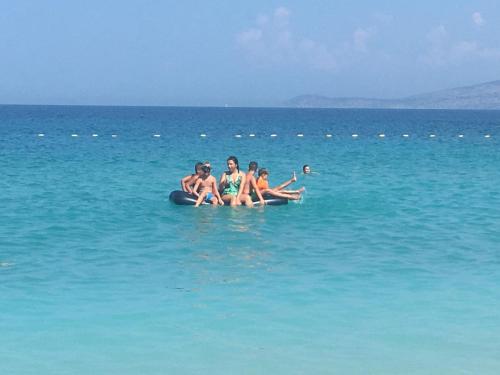 a group of people sitting on an inner tube in the water at Mana Apartments in Ksamil
