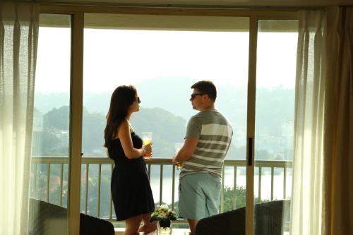 a man and a woman standing in front of a window at Thilanka Hotel in Kandy