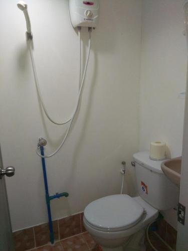 a bathroom with a white toilet and a shower at Baan I Mhok Suanphueng in Suan Phung
