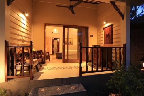 a house with a balcony with a door to a room at Puri Mas Boutique Resort & Spa in Senggigi 