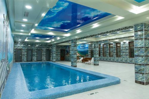 una piscina en una casa con techo en Daniel Hill Hotel, en Tashkent