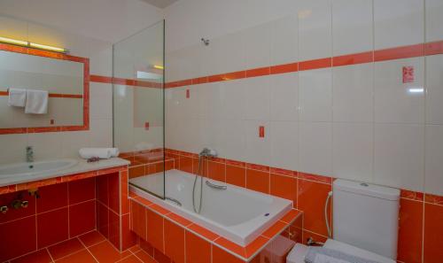 uma casa de banho com uma banheira, um lavatório e um WC. em Evgenia Apartment em Lerápetra