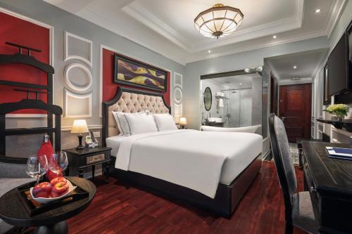 a bedroom with a large white bed and a desk at Acoustic Hotel & Spa in Hanoi